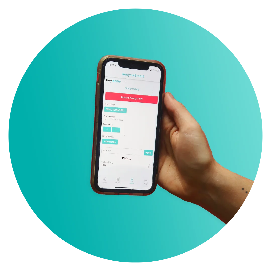 A hand holding a smartphone displaying a recycling or pickup scheduling app with options to book and verify pickup details, on a teal background.