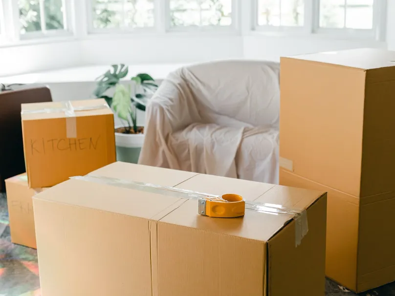 Taped cardboard boxes stacked in a bright living room