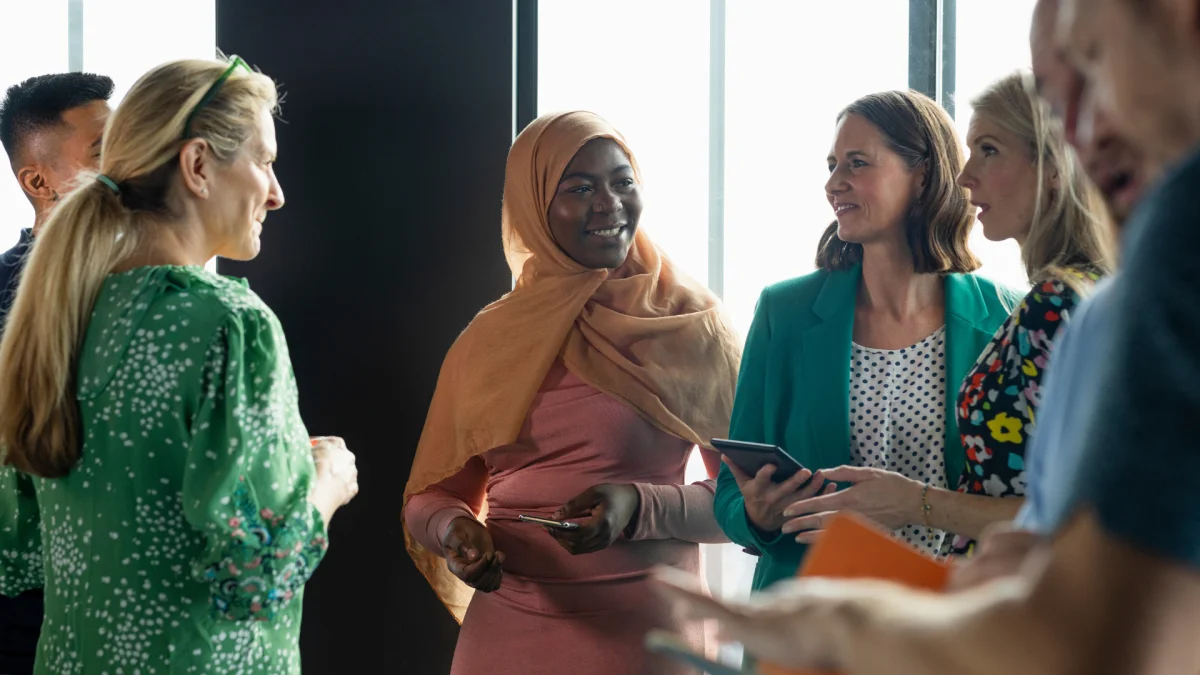 Three smiling colleagues looking at a tablet together