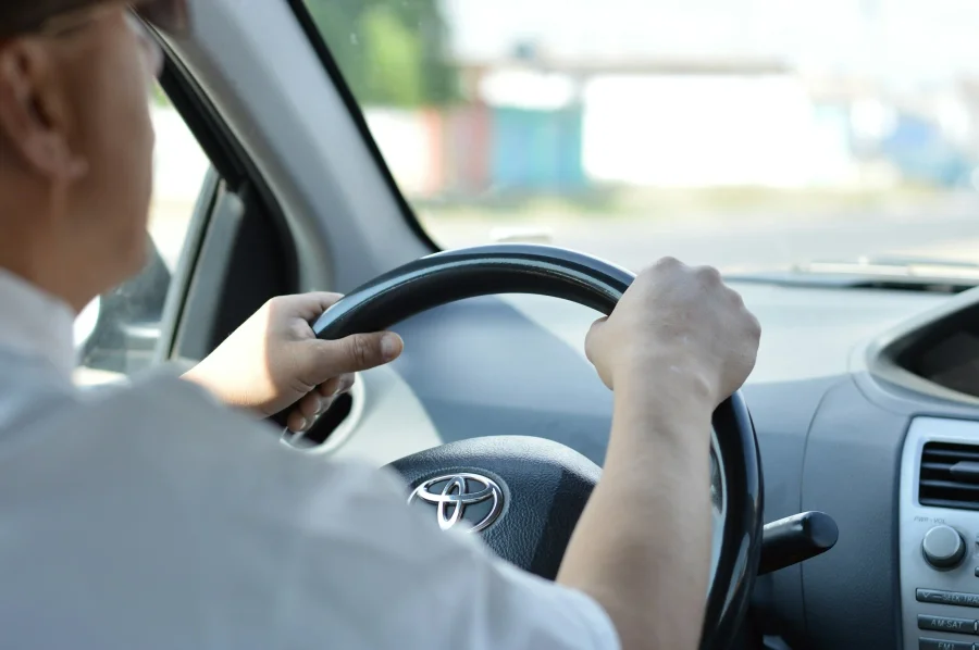 Hands on the steering wheel of a car