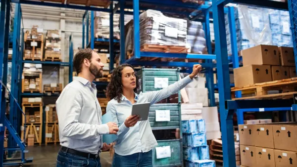 Two colleagues planning a recycling setup in a warehouse