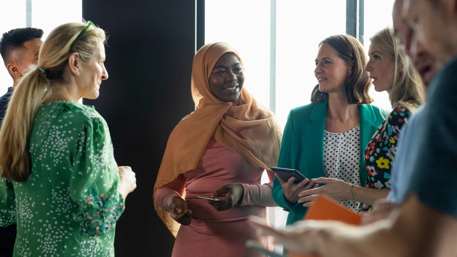 Three colleagues smiling while looking at a tablet together
