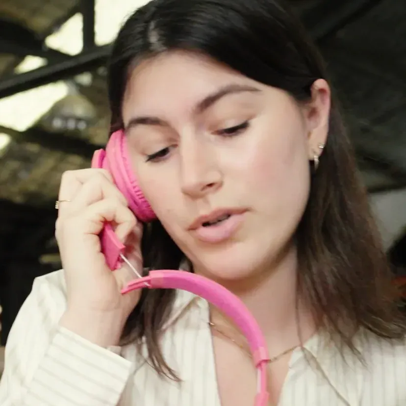 Woman in pink headphones talking on the phone