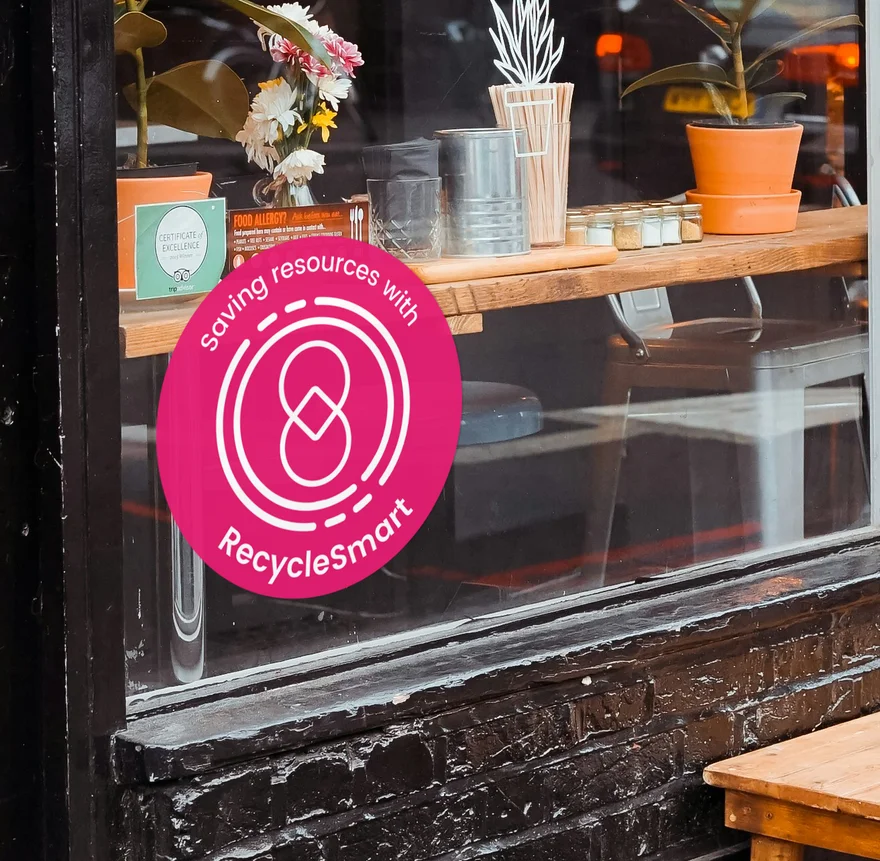 Shop window with a pink circular ReSmart sticker promoting resource saving and recycling