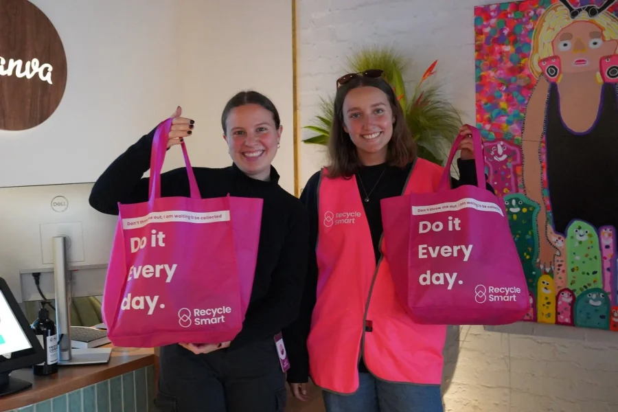 Two Canva staff holding pink ReSmart bags in their office