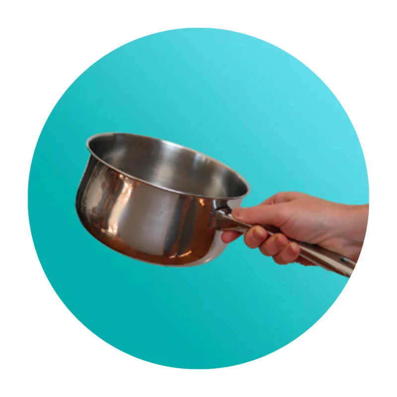 Hand holding a stainless steel saucepan